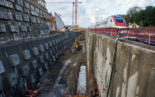 A train passing by the Eppenberg Tunnel construction site.
